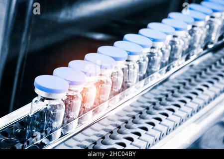 Glass bottles in production in the tray of an automatic liquid dispenser; a line for filling medicines against bacteria and viruses; antibiotics and v Stock Photo