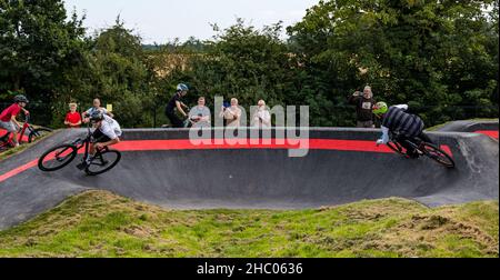 Children riding bicycles at opening event at Ormiston BMX pump track, East Lothian, Scotland, UK Stock Photo