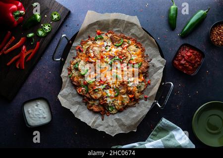 Top down view of cactus cut nachos surrounded by ingredients and dips. Stock Photo