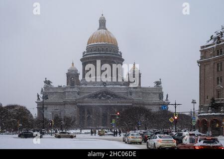 Saint-Petersburg, Russia. - 04 December 2021. View of square, busy city street with stream of cars and magnificent St. Isaac's Cathedral in snowfall i Stock Photo