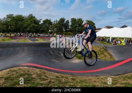 Boy riding a bicycle doing a wheelie at Ormiston BMX pump track, East Lothian, Scotland, UK Stock Photo