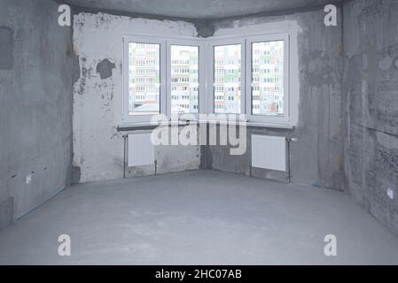 Belarus, Minsk, December 21, 2021, apartment interior without finishing in gray tones with large windows Stock Photo