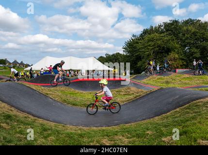 Children riding bicycles at opening event at Ormiston BMX pump track, East Lothian, Scotland, UK Stock Photo