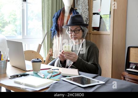 The senior Asian designer working in the studio. Stock Photo