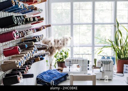 Sewing dressmaker Studio Small Business. Fashion designer working studio, with mannequin, thread spools and sewing machines on the background Stock Photo