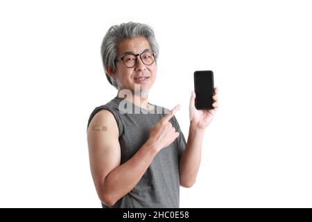 The senior Asian man showing plaster on his shoulder. Stock Photo