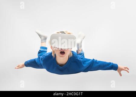 Boy flies in virtual reality glasses. White background. Virtual reality games.