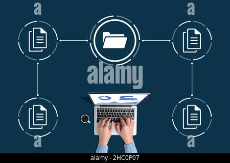 Concept document management system or DMS. A person with a laptop works with data archives Stock Photo
