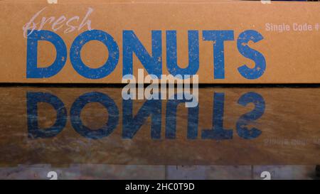 Donut cardboard box with the words Fresh Donuts and reflection on marble kitchen counter top. Stock Photo