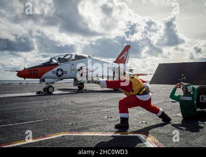 Lt. Cmdr. Rob Nelson, left, a shooter assigned to the aircraft carrier USS George H.W. Bush (CVN 77), gives the signal to launch a T-45C Goshawk aircraft from GHWB’s flight deck. The aircraft is assigned to Training Air Wing (TW) 1. Chief of Naval Air Training is conducting a carrier qualification detachment aboard GHWB. The detachment is the first opportunity for student naval aviators from Training Air Wings 1 and 2 to launch from and land on an aircraft carrier at sea, a mission-critical phase in undergraduate strike and E2/C2 pilot training. GHWB provides the national command authority fle Stock Photo