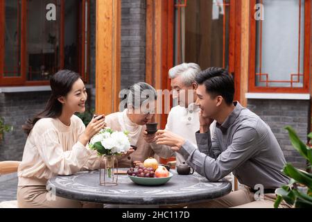 Happy families drinking tea and chatting in the courtyard Stock Photo