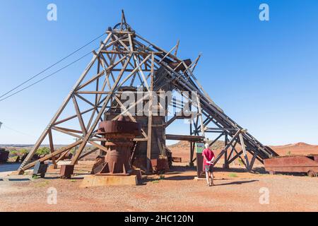 Tourist reading information about the Sons of Gwalia Headframe and Winder Engine on display at Gwalia Museum, Gwalia near Leonora, Western Australia, Stock Photo