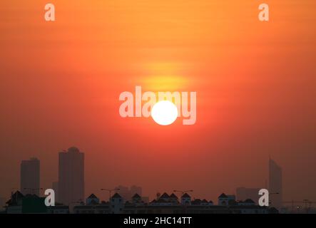 Bright sun on the amazing orange sky over group of skyscrapers Stock Photo