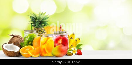 Assorted Exotic fruits with juice cocktails in mason jars on white table . Stock Photo