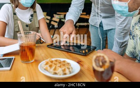 Unrecognizable friends using tablet in a coffee shop Stock Photo