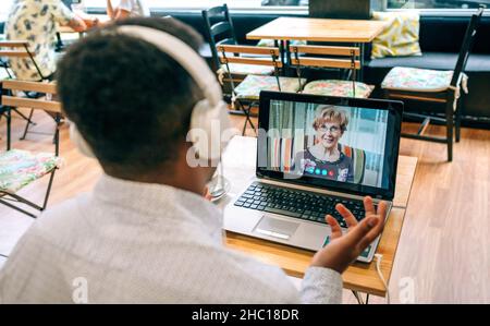 Man talking on video call with his mother from a cafeteria Stock Photo