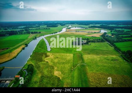 Drone view of the river Vecht, green grass, trees, beautiful blue sky and cycle path through the Vecht valley. Bridge and weir in the river. Dalfsen N Stock Photo