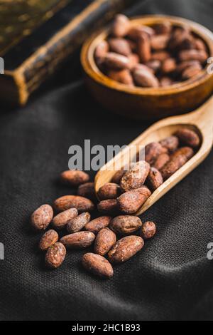 Dried cocoa beans. Cacao beans in wooden scoop. Stock Photo