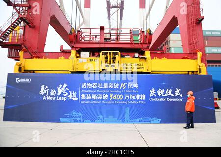 QINGDAO, CHINA - DECEMBER 23, 2021 - A dock worker looks at the 34 million teUs of Shandong Port Group at the Qingdao Port foreign trade container ter Stock Photo