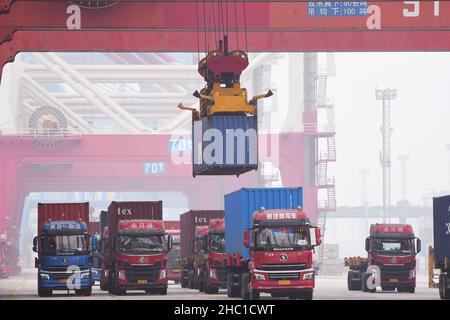 QINGDAO, CHINA - DECEMBER 23, 2021 - A bridge crane is used to lift containers to cargo ships at the Qingdao Foreign trade container Terminal in Qingd Stock Photo