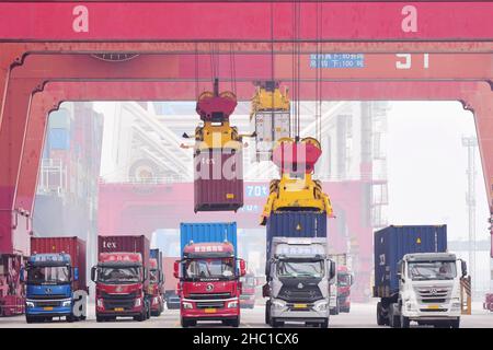 QINGDAO, CHINA - DECEMBER 23, 2021 - A bridge crane is used to lift containers to cargo ships at the Qingdao Foreign trade container Terminal in Qingd Stock Photo