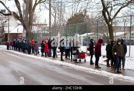 Toronto, Canada. 20th Dec, 2021. People line up to enter a COVID-19 vaccination clinic in Toronto, Canada, on Dec. 20, 2021. Canada reported 10,621 new COVID-19 cases on Monday, the first increase of over 10,000 cases in a single day since the COVID-19 pandemic hit the country in February 2020. The new cases have raised the country's cumulative caseload to 1,894,981, including 30,060 deaths, according to CTV. Credit: Zou Zheng/Xinhua/Alamy Live News Stock Photo