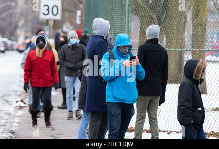 Toronto, Canada. 20th Dec, 2021. People line up to enter a COVID-19 vaccination clinic in Toronto, Canada, on Dec. 20, 2021. Canada reported 10,621 new COVID-19 cases on Monday, the first increase of over 10,000 cases in a single day since the COVID-19 pandemic hit the country in February 2020. The new cases have raised the country's cumulative caseload to 1,894,981, including 30,060 deaths, according to CTV. Credit: Zou Zheng/Xinhua/Alamy Live News Stock Photo