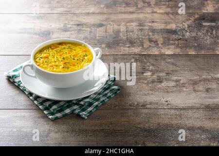 Chicken noodle soup in white bowl on wooden table Stock Photo