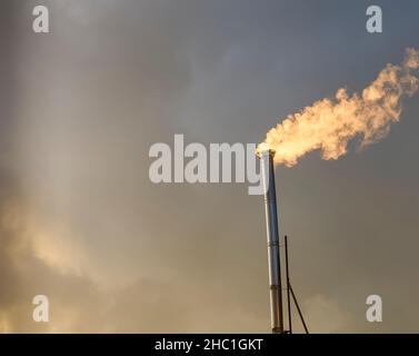 Smoke rising from stainless steel industrial chimney. Stock Photo