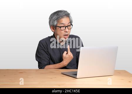 The senior Asian man sitting at the desk. Stock Photo