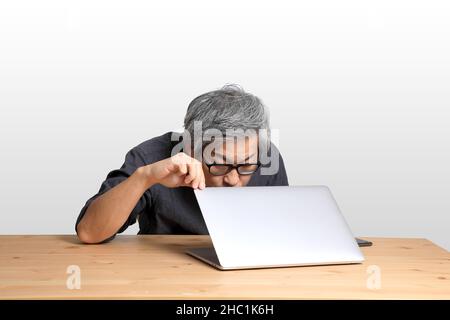 The senior Asian man sitting at the desk. Stock Photo