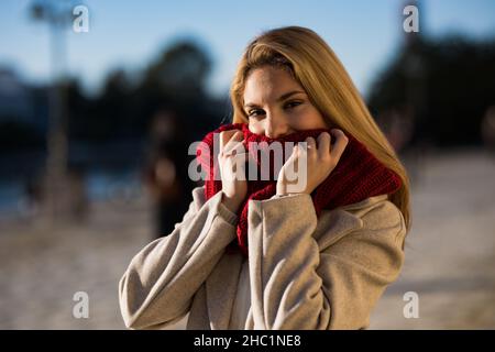 Young teenage girl with a red scarf in the city at sunset. Stock Photo