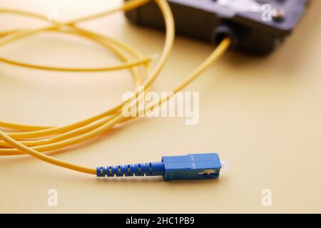 Wi-Fi router with cables on yellow background  Stock Photo