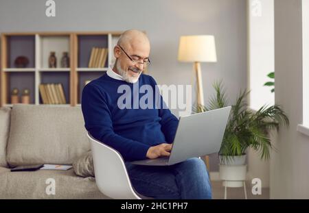 Senior laptop. Mature online. An elderly man at home communicates online using a laptop. Older people and technology. Stock Photo