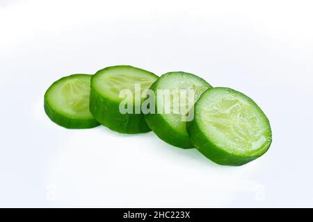 Cucumber slices, closeup photo of ripe cucumber slices isolated on white background. Stock Photo