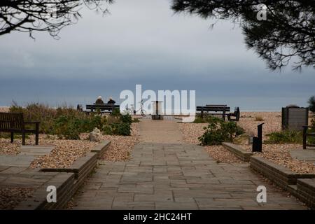 Two pensioners sitting on a bench at the seaside. Stock Photo