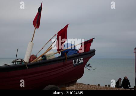 Red flags seen on a small fishing boat on the beach in the UK. Stock Photo