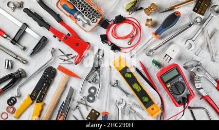 Set of hand tools on white plaster background. Work tools for electrician, carpenter, mechanic, plumber and hobist. Top view, flat lay. Stock Photo