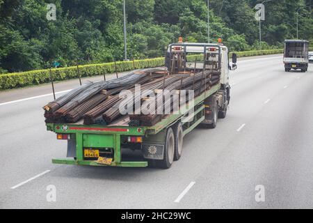 A trailer truck moving on the road carry long steels on the road to the next offload destination. Singapore. Stock Photo