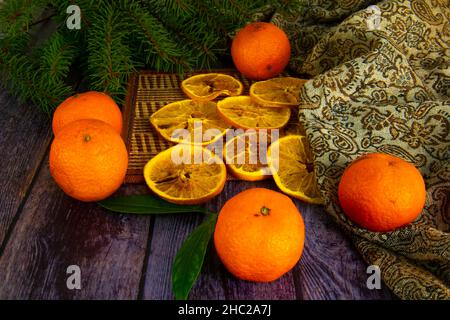 Dried oranges, fresh tangerines and Christmas tree on a old wooden table Stock Photo