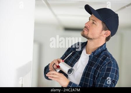 young technician installing security camera Stock Photo