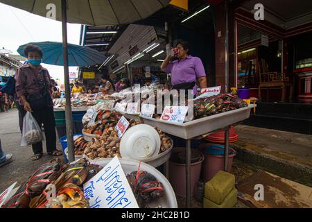 Mahachai Samutsakhon, Thailand - November 7, 2020 : Unidentified people wear surgical mask and choosing seafood fish at Mahachai fresh market Stock Photo