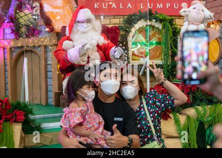 Kuala Lumpur, Malaysia. 23rd Dec, 2021. People pose for photos in front of Christmas decorations at a shopping mall in Kuala Lumpur, Malaysia, Dec. 23, 2021. Credit: Chong Voon Chung/Xinhua/Alamy Live News Stock Photo