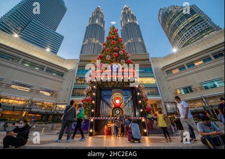 Kuala Lumpur, Malaysia. 23rd Dec, 2021. People pose for photos in front of a Christmas tree in Kuala Lumpur, Malaysia, Dec. 23, 2021. Credit: Chong Voon Chung/Xinhua/Alamy Live News Stock Photo