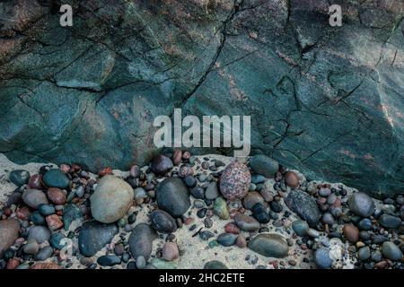 Vibrantly coloured rock and pebbles on the Isle of Iona. Stock Photo