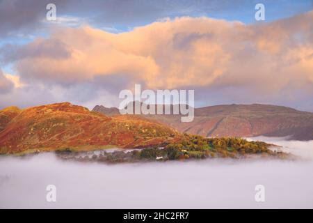 Looking over morning mist towards Lingmoor Fell and the Langdale Pikes. Stock Photo