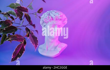 Colorful neon image with greek sculpture, surreal art style. Head of a statue David by Michelangelo. Copy space. Stock Photo