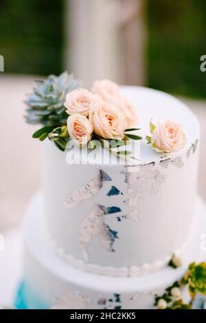 Top tier of a wedding cake decorated with roses and succulents Stock Photo