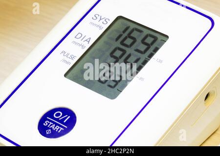 The digital blood pressure monitor shows very high arterial blood pressure and heart rate. Medical pressure measuring device. Diastolic and systolic Stock Photo
