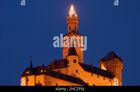 Braubach, Germany. 23rd Dec, 2021. A Christmas tree lights up on the tower of Marksburg Castle on the Middle Rhine near Braubach. Marksburg Castle, which stands on a 160-metre-high slate cone high above the Rhine, is the only medieval hilltop castle on the Rhine that has never been destroyed. Credit: Thomas Frey/dpa/Alamy Live News Stock Photo